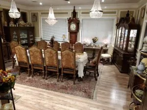 Elegant dining room with a long table, chandeliers, and antique furniture displayed at an estate sale hosted by C'z Estate Sales LLC.